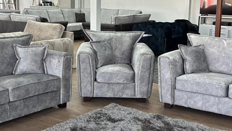 Serena Elegant Grey Fabric Armchair with Metal Trim and Quilted Sides