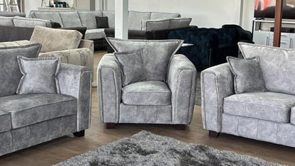 Serena Elegant Grey Fabric Armchair with Metal Trim and Quilted Sides